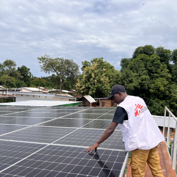 Goumar Attama Abdoul Aziz, gerente de energia de MSF, inspeciona um painel de energia solar no Hospital de Batangafo, na República Centro-Africana. ©Amadou Barazé