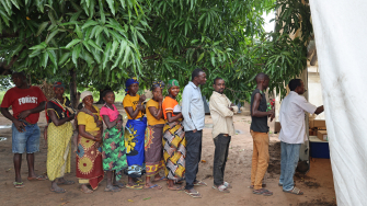 Um grupo de pessoas deslocadas aguarda em fila, do lado de fora de uma clínica móvel de MSF, em Alua Velha, distrito de Eráti, província de Nampula. ©Sofia Minetto/MSF
