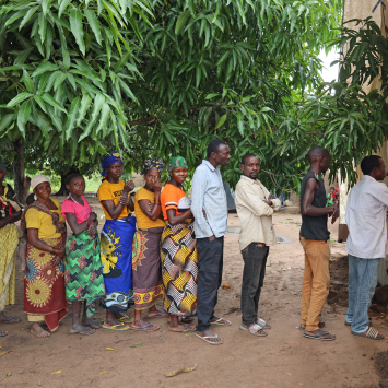 Um grupo de pessoas deslocadas aguarda em fila, do lado de fora de uma clínica móvel de MSF, em Alua Velha, distrito de Eráti, província de Nampula. ©Sofia Minetto/MSF