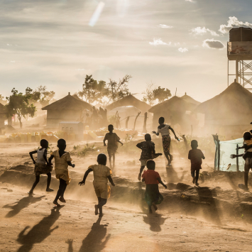 Foto: Frederic NOY/COSMOS
Legenda: Crianças do Sudão do Sul brincando no acampamento de refugiados de Bidibidi, em Uganda, em frente às instalações da MSF. Maio de 2017.