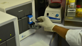 Uma amostra para detecção de tuberculose é inserida na máquina GeneXpert no laboratório de MSF no Hospital Geral de Kerema. Papua-Nova Guiné, 2017. © Sophie McNamara/MSF