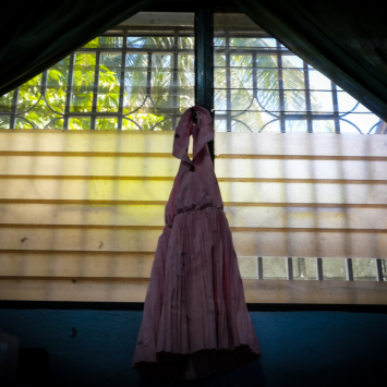 Um vestido infantil pendurado em uma das janelas da Kay ble. “Kay ble” (“Casa azul”, na língua crioula) é um dormitório localizado na clínica Pran Men’m, que oferece acomodação temporária de emergência para sobreviventes que não podem voltar para casa em segurança. Haiti. ©MSF