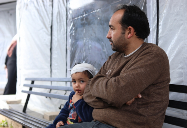Mahmoud Al-Dahdouh, com seu filho, que foi atingido por um tiro na cabeça. @ Nour Alsaqqa/MSF