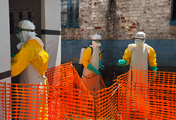 Equipe de MSF caminha para a área de isolamento no Hospital Geral de Referência de Mongbwalu, na província de Ituri, na República Democrática do Congo, para atender pacientes com suspeita da doença do Ebola. ©Anna Schönhofer