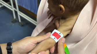 Enfermeira mede a circunferência do braço (MUAC) de um bebê no centro ambulatório de alimentação terapêutica de MSF, no sul do Afeganistão. 
©Nazia Kamal/MSF