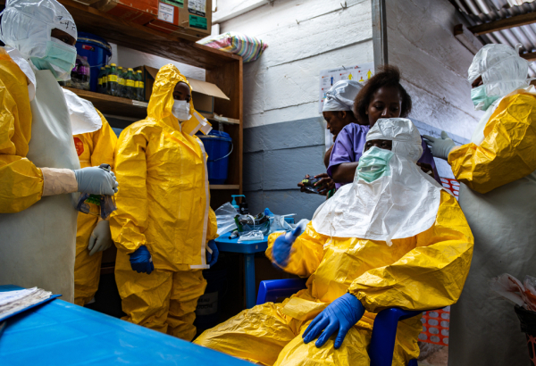 Equipe de profissionais de MSF se prepara para entrar na área isolada do Centro de Tratamento de Ebola, na RDC. © Lucie Ringué