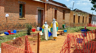 Profissionais de saúde em frente às enfermarias onde os pacientes diagnosticados com a doença do Ebola recebem atendimento no Centro de Tratamento de MSF, em Ituri, República Democrática do Congo. ©Kristen Poels/MSF