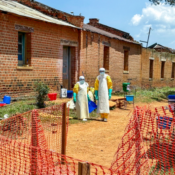 Profissionais de saúde em frente às enfermarias onde os pacientes diagnosticados com a doença do Ebola recebem atendimento no Centro de Tratamento de MSF, em Ituri, República Democrática do Congo. ©Kristen Poels/MSF