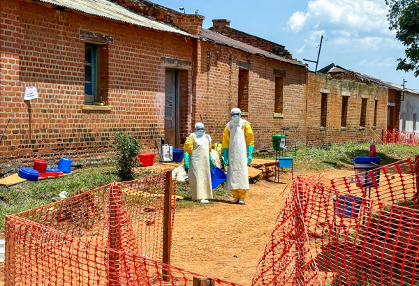 Profissionais de saúde em frente às enfermarias onde os pacientes diagnosticados com a doença do Ebola recebem atendimento no Centro de Tratamento de MSF, em Ituri, República Democrática do Congo. ©Kristen Poels/MSF