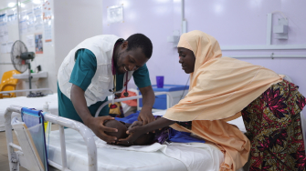Profissional de MSF examina paciente em tratamento para desnutrição no no Centro de Internação para Alimentação Terapêutica em Katsina, na Nigéria. 2026. © Abba Adamu Musa/MSF