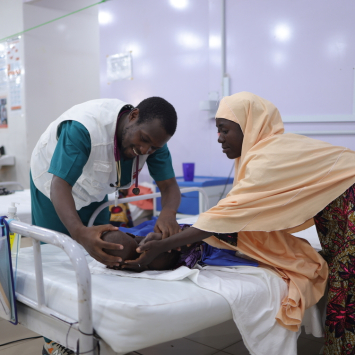 Profissional de MSF examina paciente em tratamento para desnutrição no no Centro de Internação para Alimentação Terapêutica em Katsina, na Nigéria. 2026. © Abba Adamu Musa/MSF