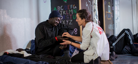 A enfermeira de MSF, Aiofe Ni Mhurchu, dá uma pílula contra enjôo a uma das 27 pessoas que foram resgatadas no mar perto de uma plataforma de petróleo ao norte de Sabratah, Líbia,